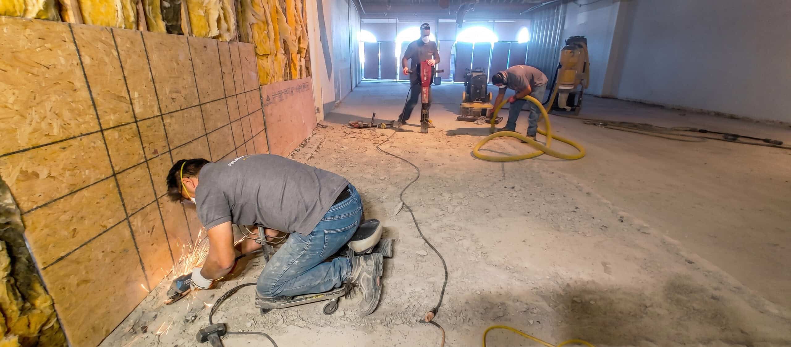 An IT'S SO CLEAN technician grinding out damaged concrete during a floor restoration