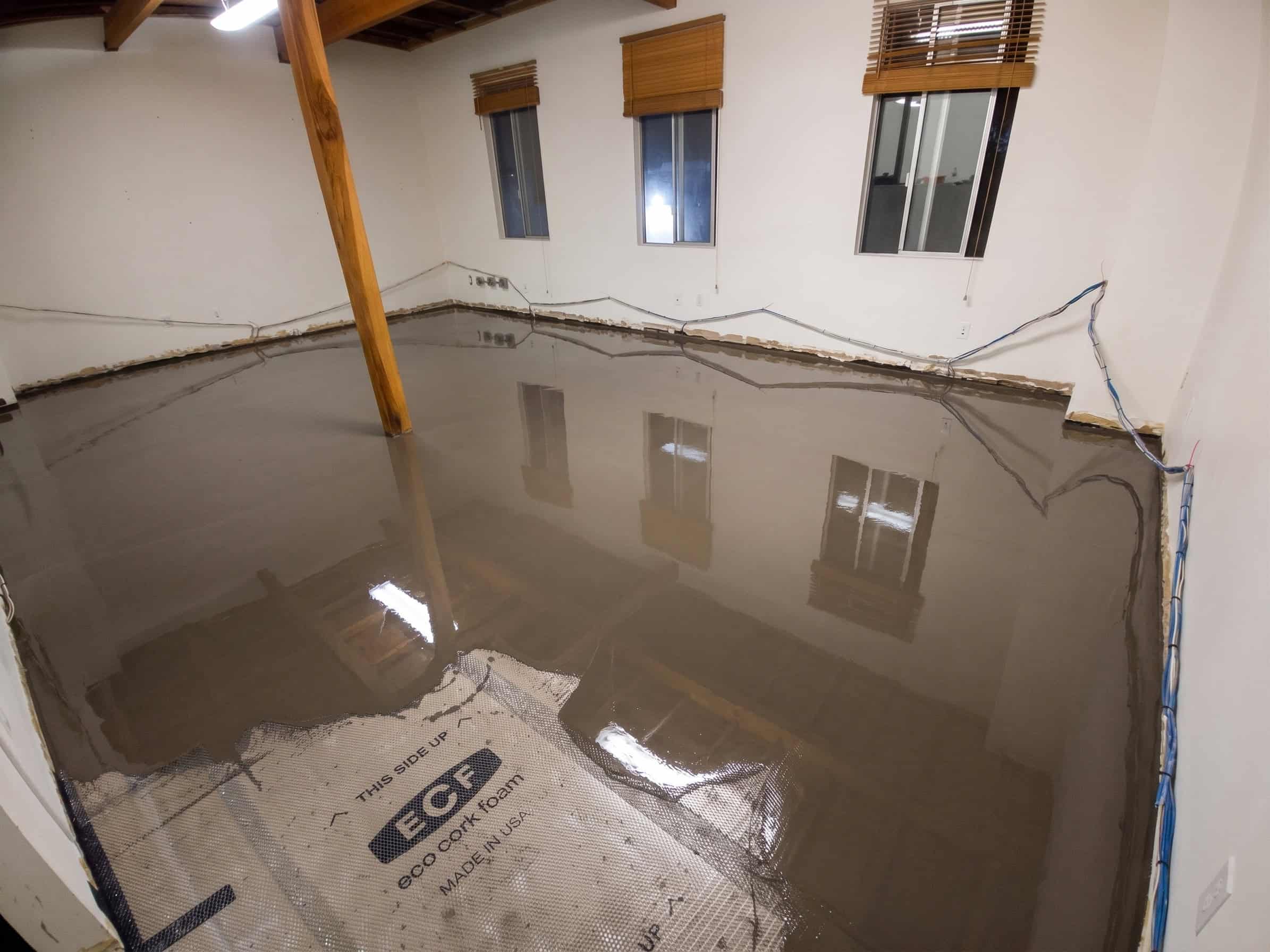 A freshly poured self-leveling surface overlay flowing out smooth over a prepared subfloor