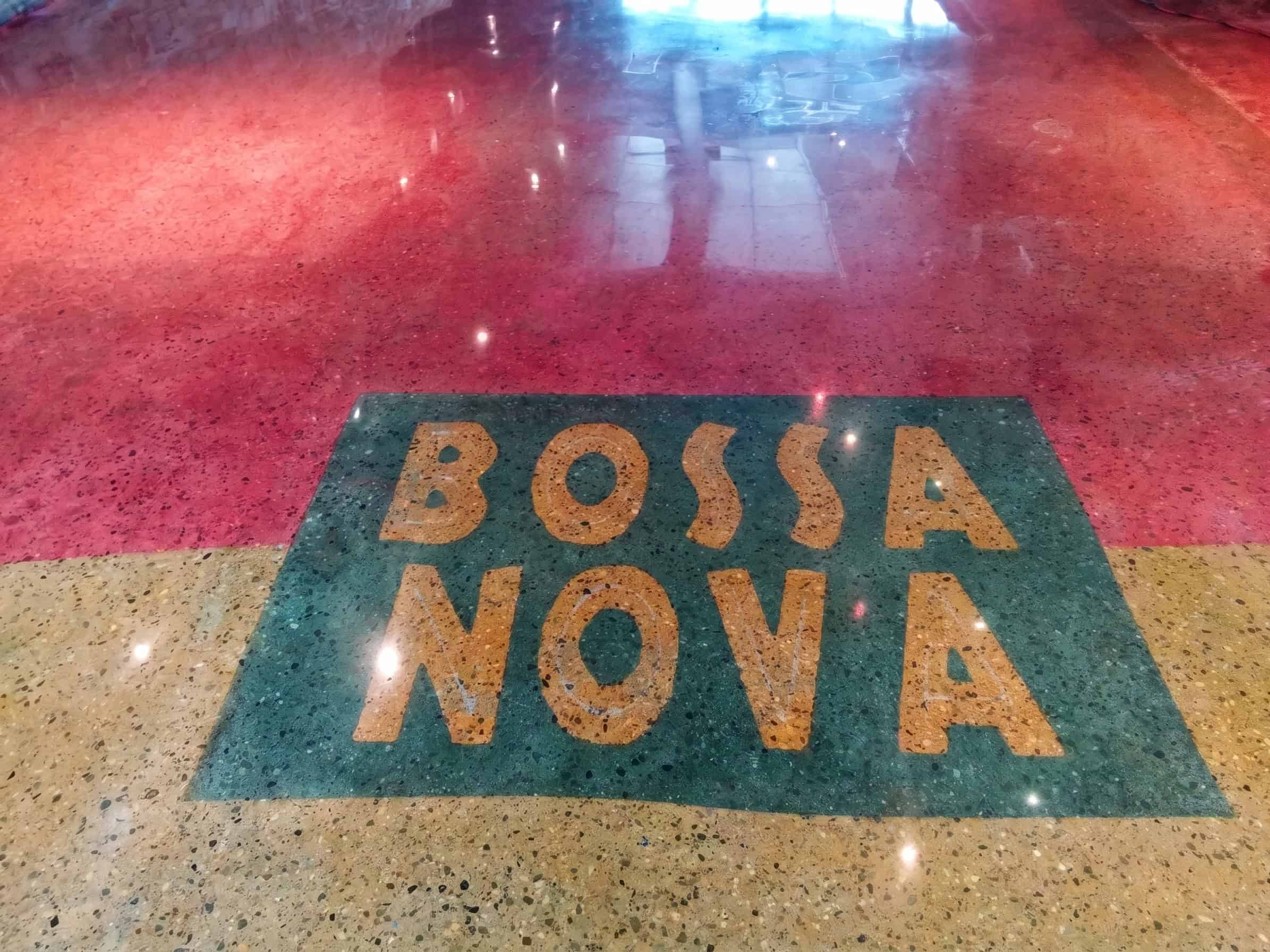 Polished concrete floor in deep red with a custom Bossa Nova logo inlaid in terrazzo