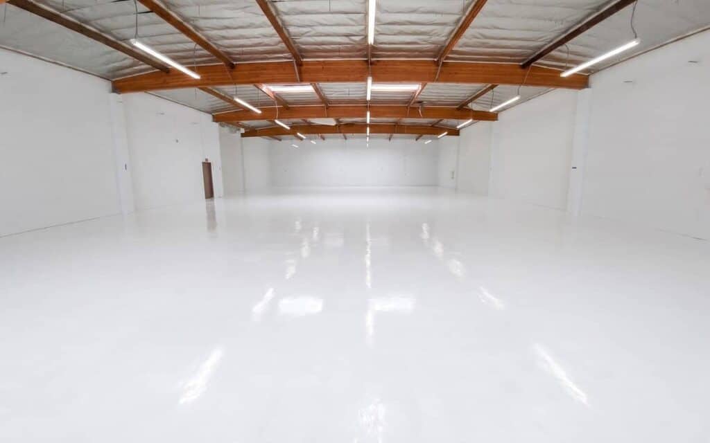 Seamless white epoxy coating across an open commercial warehouse floor