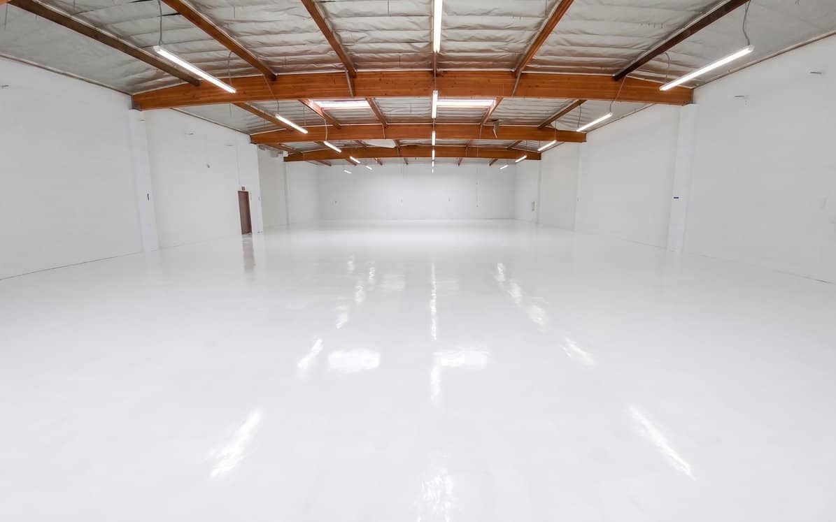 Seamless white epoxy coating across an open commercial warehouse floor