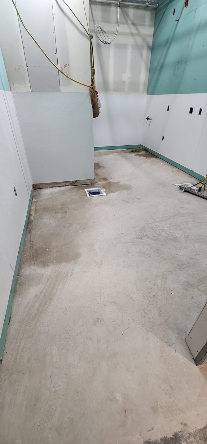 Bare concrete through the back corridor before work