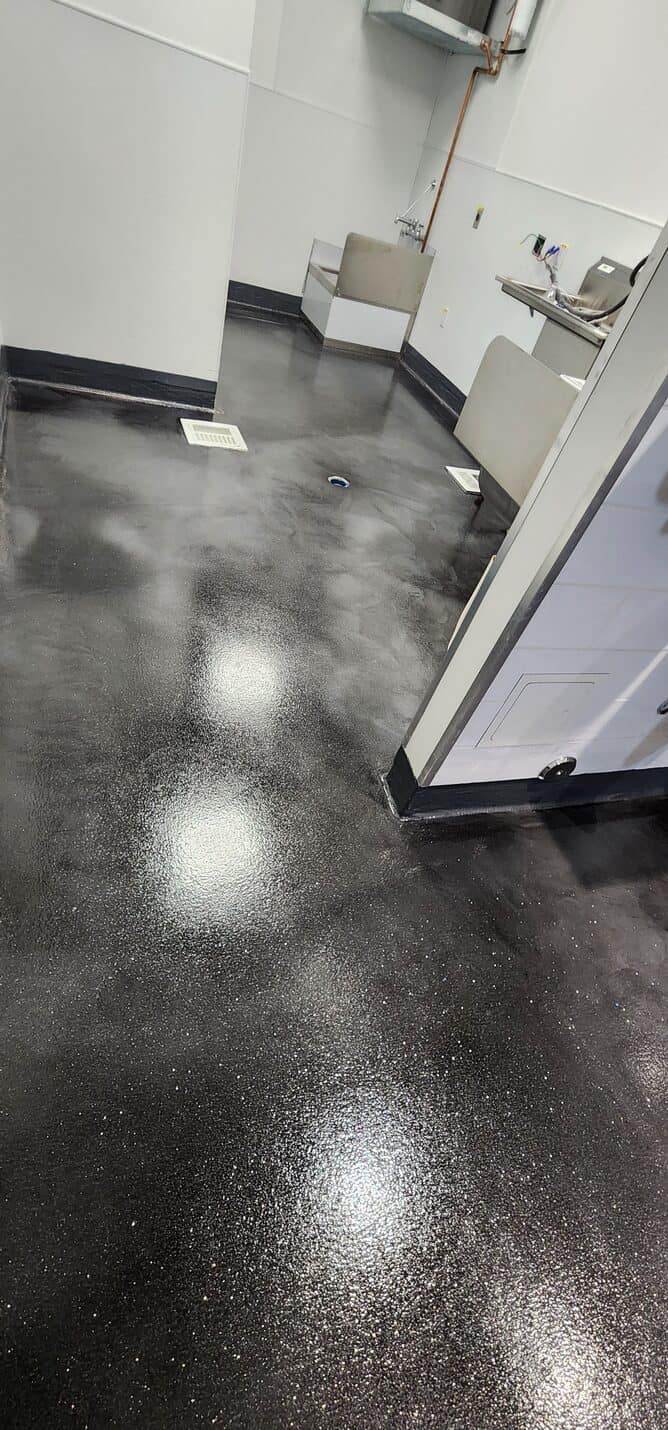 Black cove base against the metallic floor