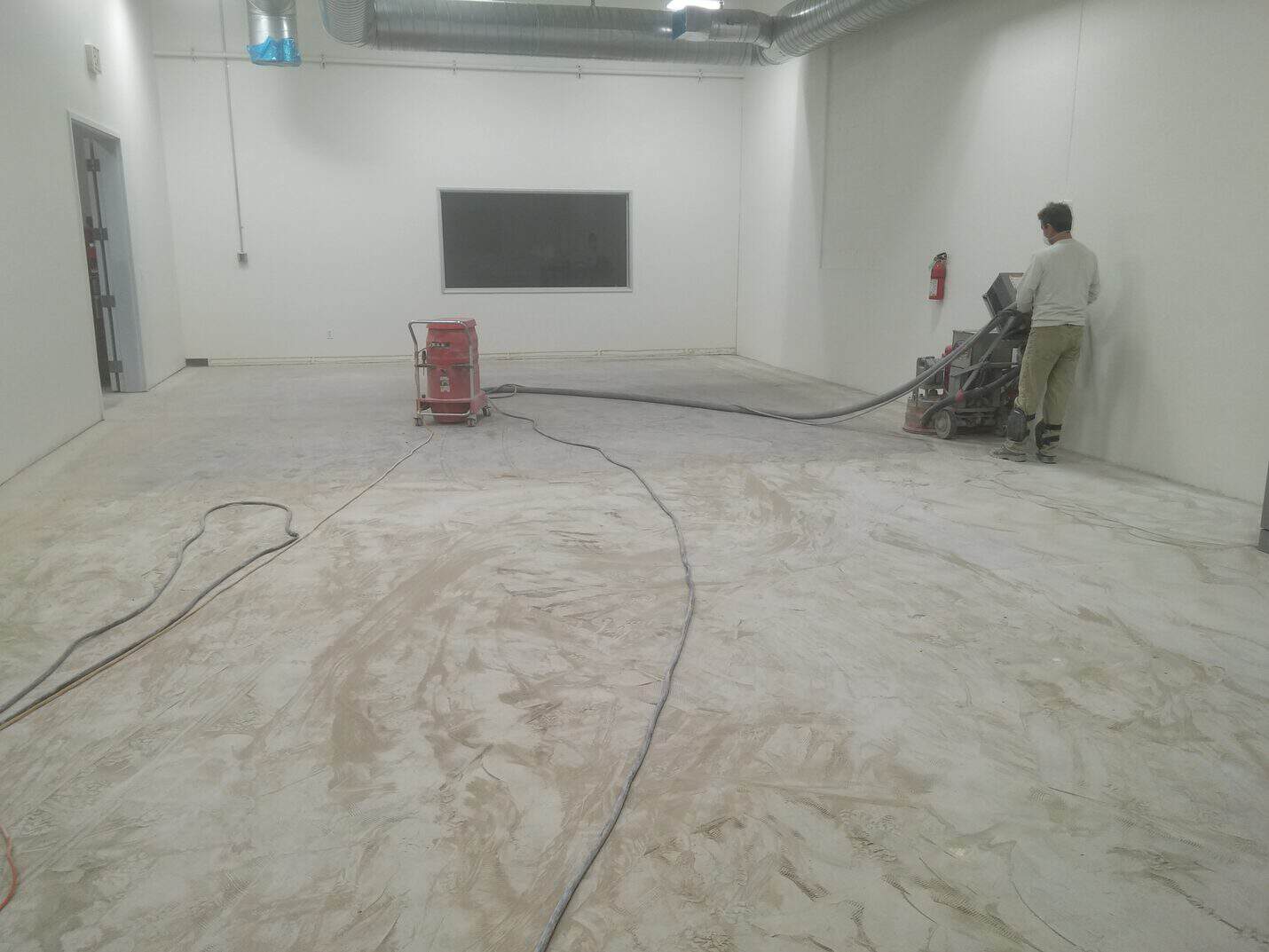 Grinding the production room floor back to clean concrete