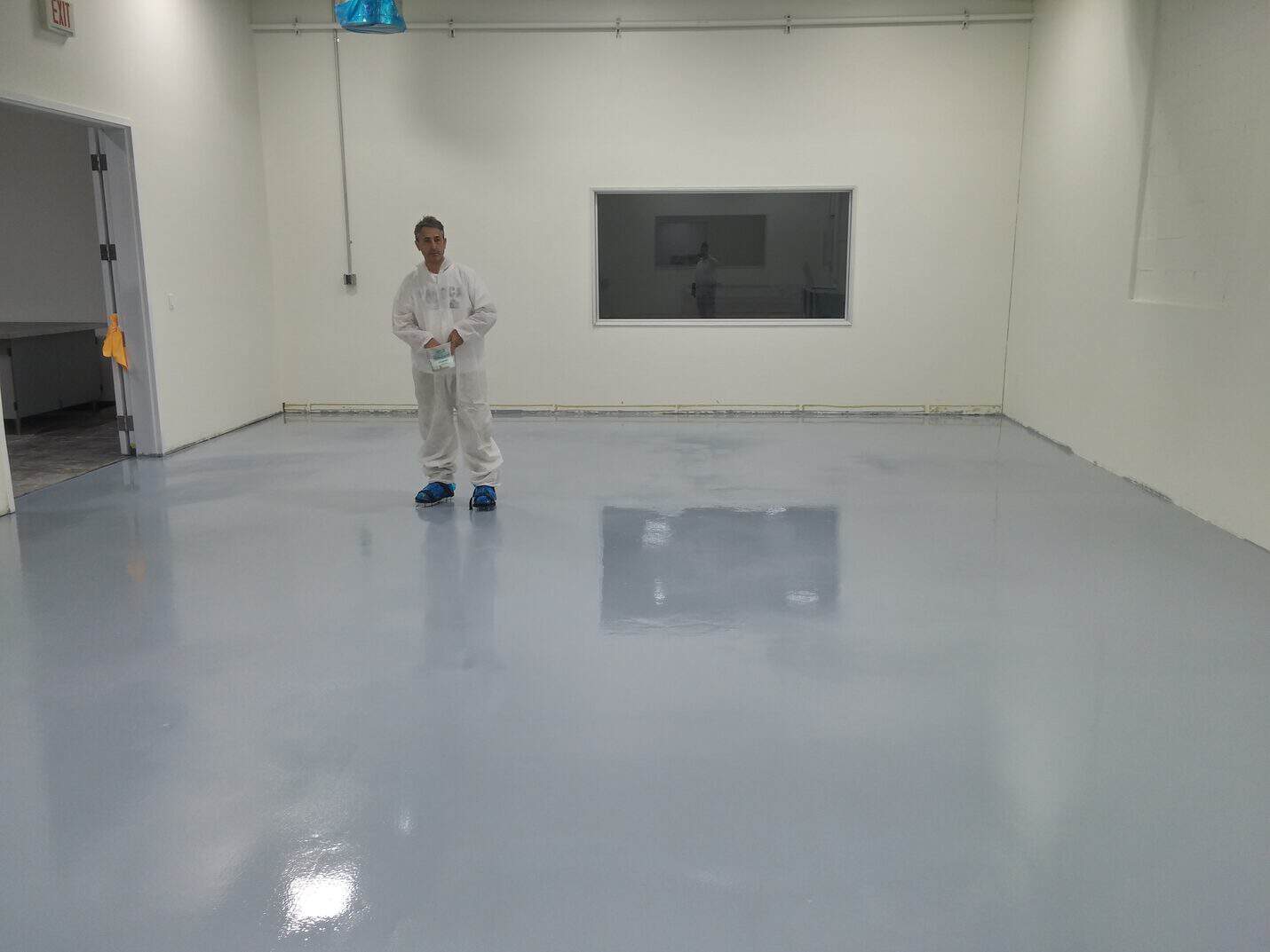 Crew in coveralls rolling the epoxy coating