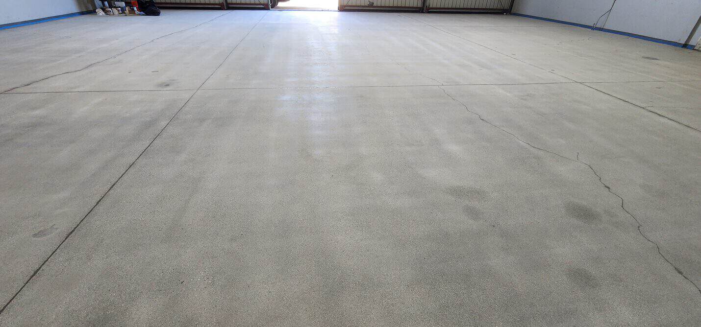 Deep blue metallic epoxy floor across the Torrance hangar