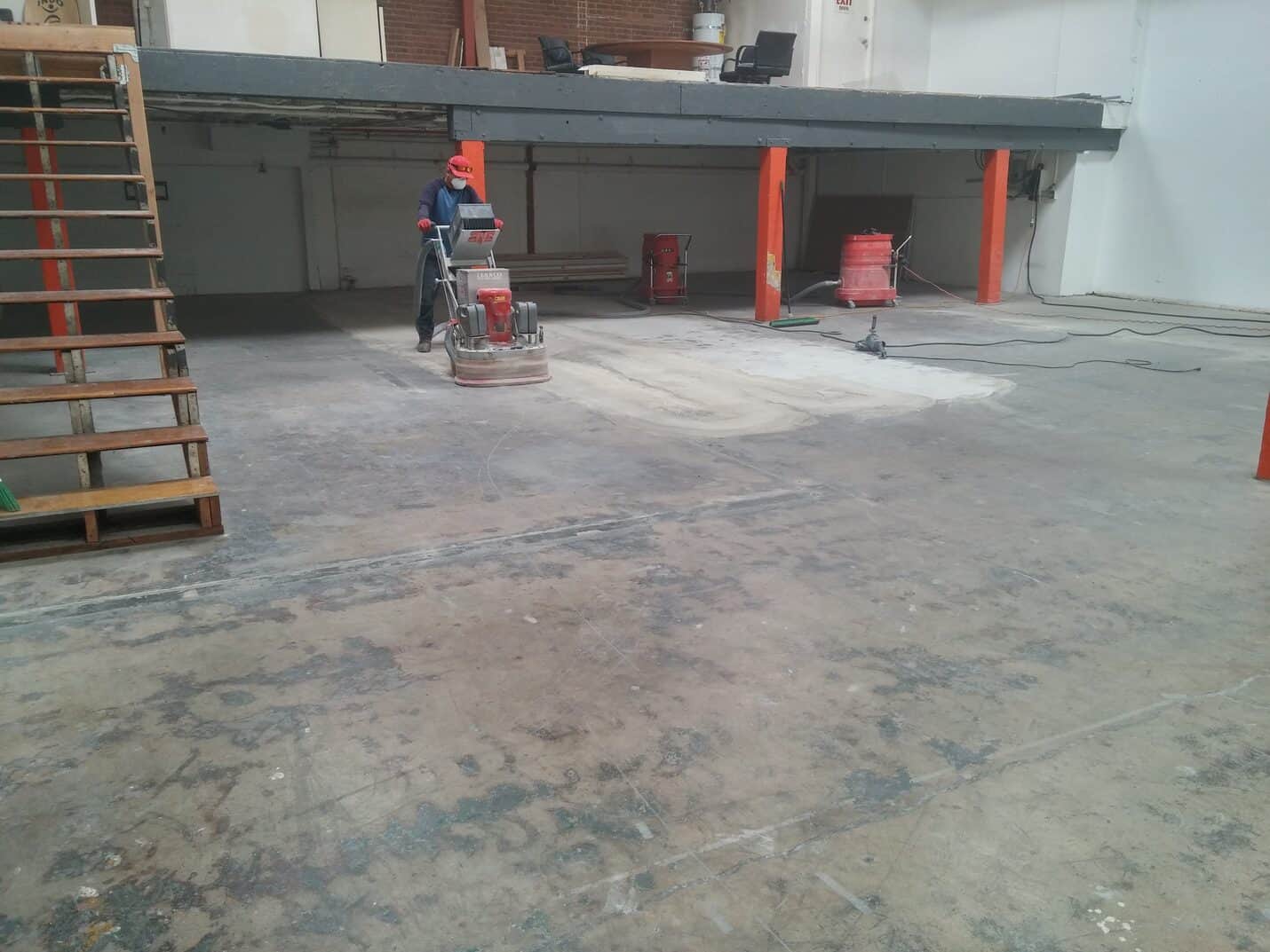 Crew grinding the studio floor with a walk behind machine