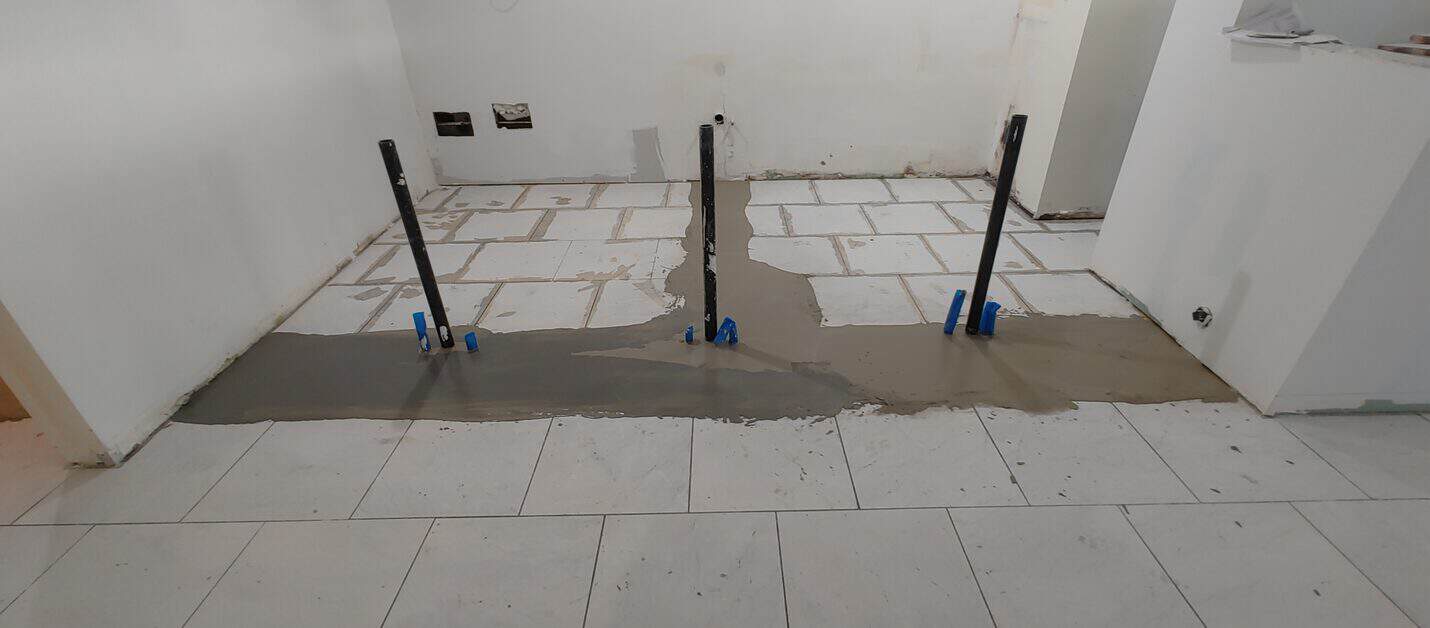 Slab patched around temporary shoring posts before coating