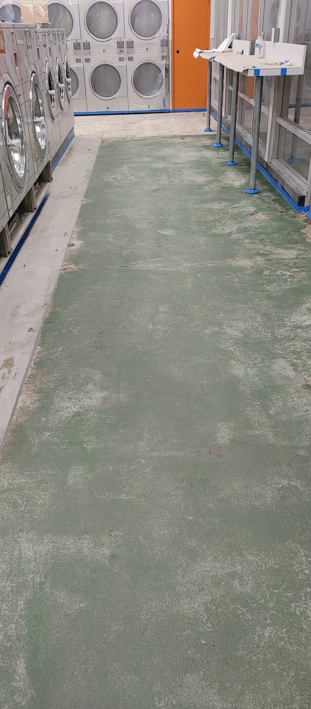 Bare concrete showing through the old coating along the walking lines