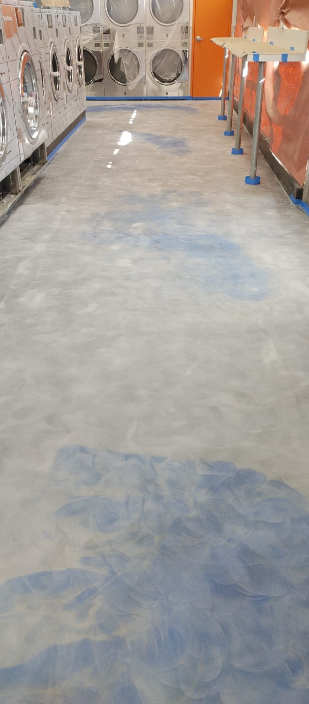 Metallic laundromat floor reflecting the washers