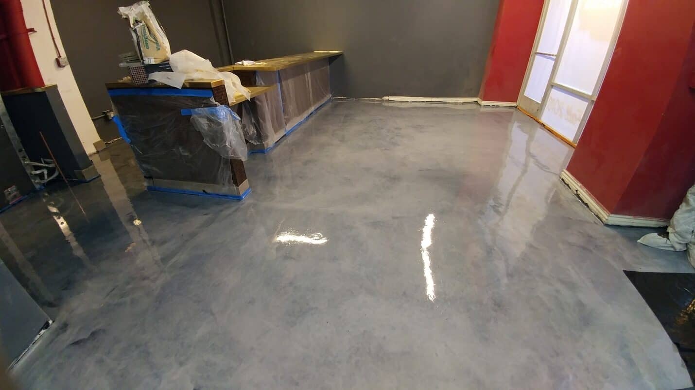 Metallic floor reflecting the red feature wall