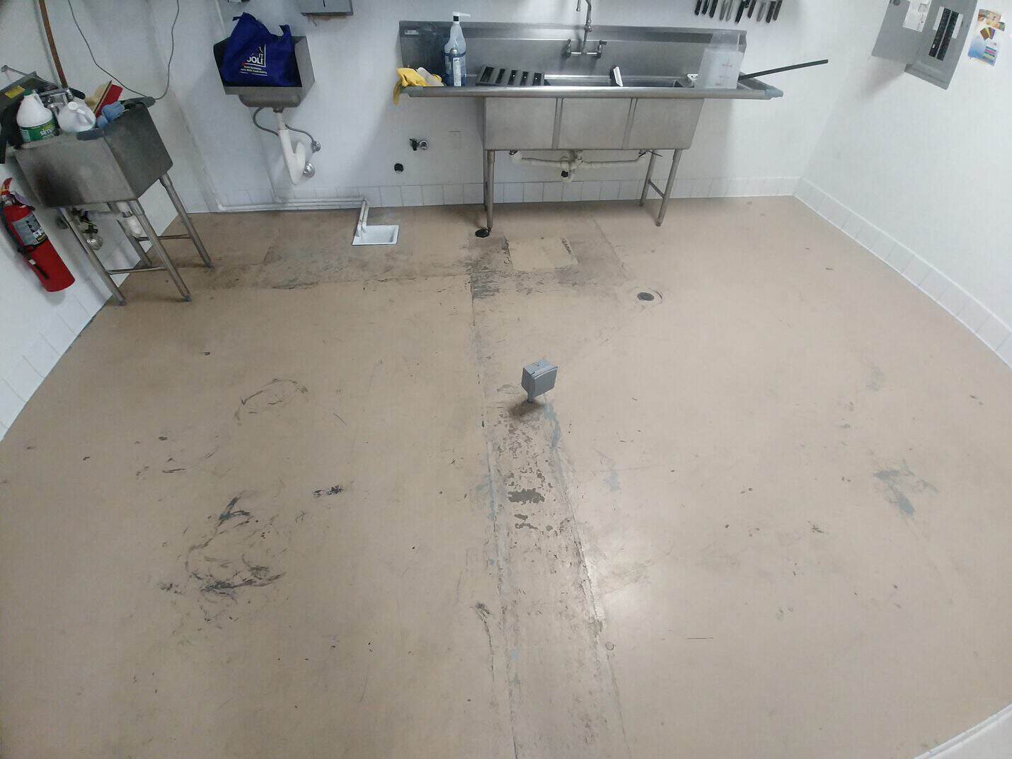 Adhesive residue and staining across the kitchen floor